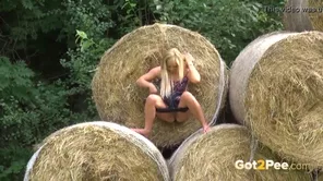 A blonde girl pissed in the yard while a farmer watched with interest